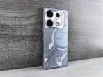 A sleek smartphone with a futuristic design rests on a wooden surface, showcasing modern technology.